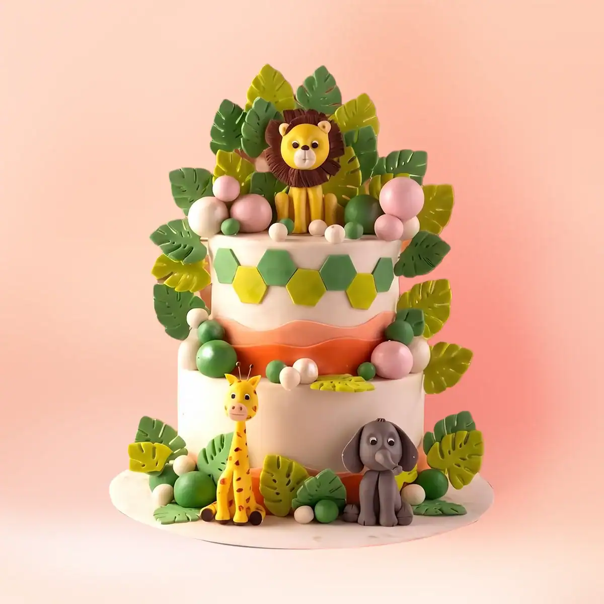 Two tier jungle theme first birthday cake in Chennai with a lion topper, giraffe and monkey figures and handmade sugar leaves in cream and green from Cake Square.