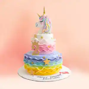 Two tier unicorn theme birthday cake in Chennai with a fondant unicorn head topper, rainbow ruffles from yellow to purple, gold stars and a crown number from Cake Square.
