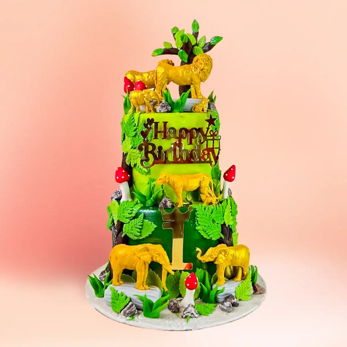Three tier jungle theme first birthday cake in Chennai with edible gold and white chocolate lion, lioness and elephant figures and a personalised number one topper from Cake Square.