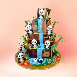 Three tier panda theme first birthday cake in Chennai with handmade panda figures on bamboo ladders and a chocolate waterfall, 7kg to 10kg with an eggless option from Cake Square.