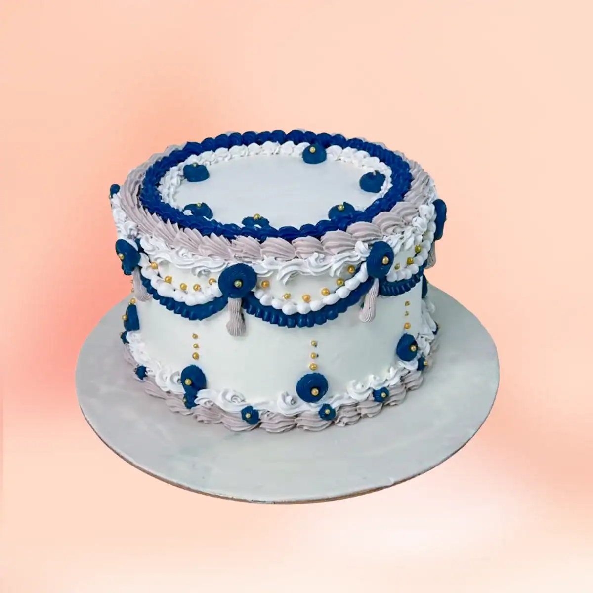 Blue and white vintage Lambeth buttercream celebration cake in Chennai with hand piped navy rosettes, gold pearls and lace detailing from Cake Square.