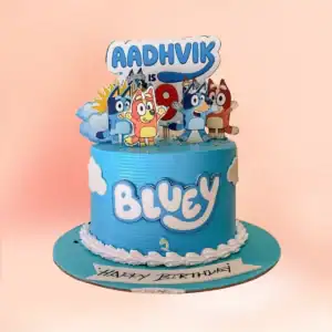 Bluey theme birthday cake in Chennai with sky blue textured buttercream, Bluey and Bingo character toppers, cloud detailing and a custom age sign from Cake Square.