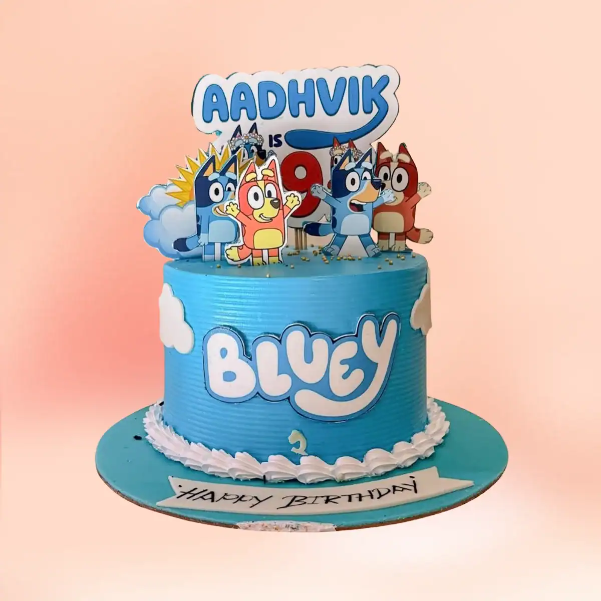 Bluey theme birthday cake in Chennai with sky blue textured buttercream, Bluey and Bingo character toppers, cloud detailing and a custom age sign from Cake Square.