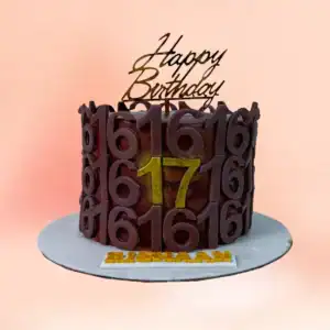 Chocolate number birthday cake in Chennai with dark chocolate bark texture, a gold age number and a custom name plaque, made for Sweet 16 and 17 celebrations by Cake Square.