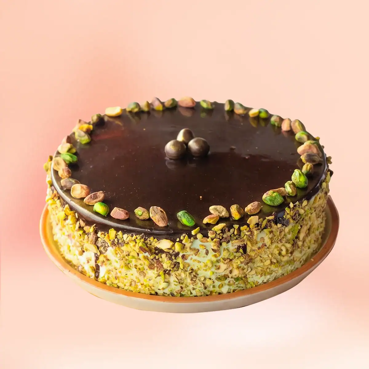 Chocolate pistachio cake in Chennai with a glossy dark chocolate top, whole pistachios and sides fully coated in crushed pistachio, delivered in 45 minutes by Cake Square.