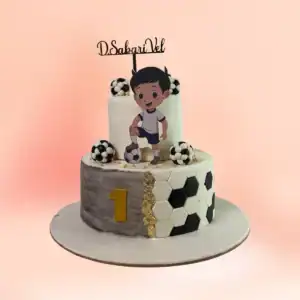 Two tier football theme first birthday cake for boys in Chennai with a marble grey top tier, a black and white hexagon panel and a custom number one topper from Cake Square.