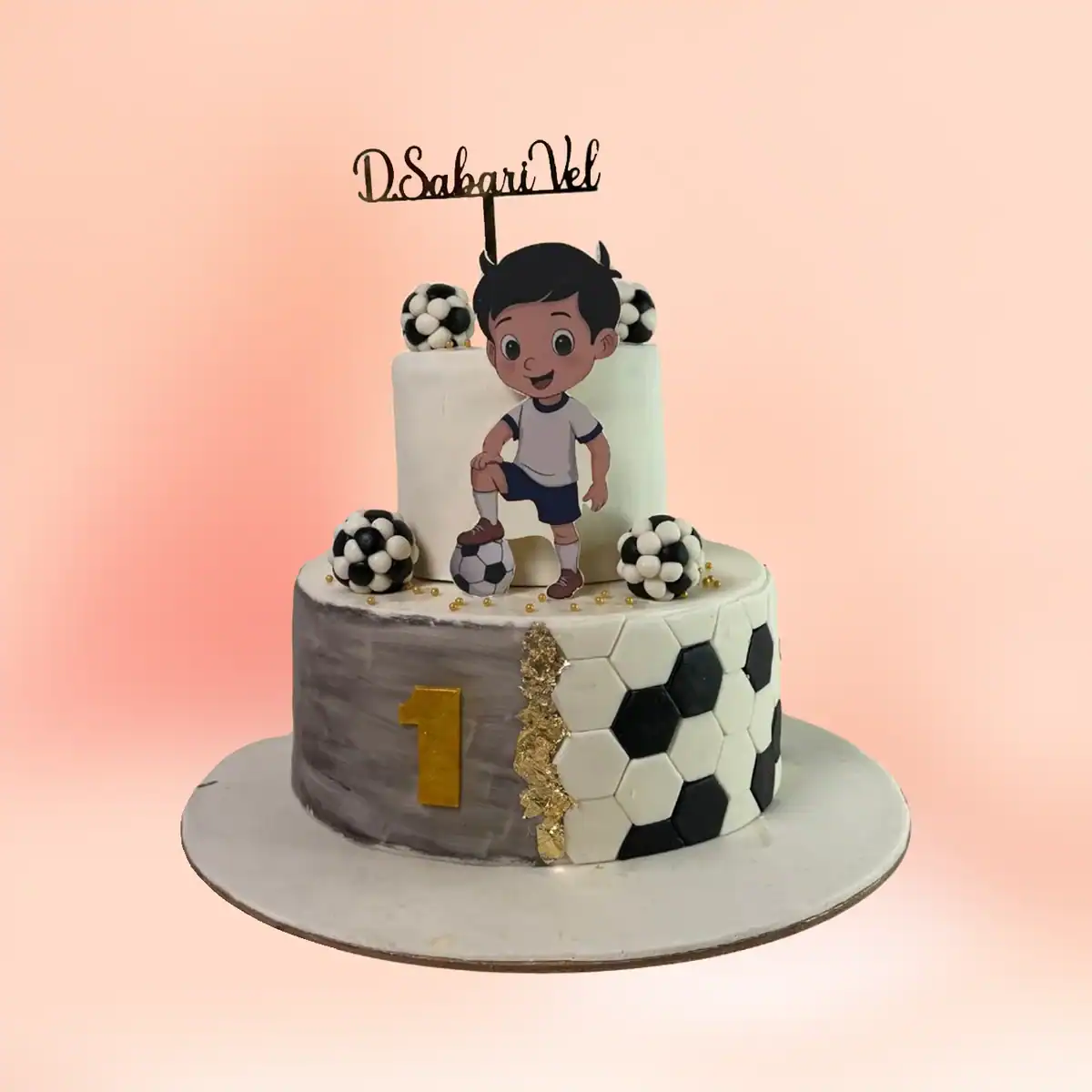 Two tier football theme first birthday cake for boys in Chennai with a marble grey top tier, a black and white hexagon panel and a custom number one topper from Cake Square.
