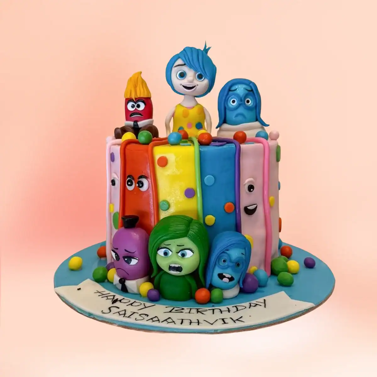 Inside Out theme birthday cake in Chennai with colour block fondant panels, Joy, Sadness, Anger, Fear and Disgust toppers and a custom name banner from Cake Square.