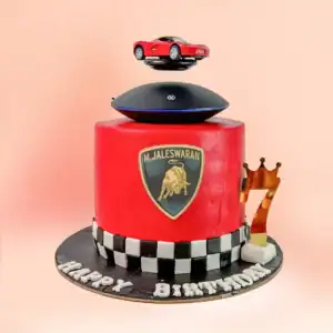 Lamborghini theme birthday cake in Chennai with red fondant, a black and white checkered base and a real magnetic levitating sports car display on top from Cake Square.