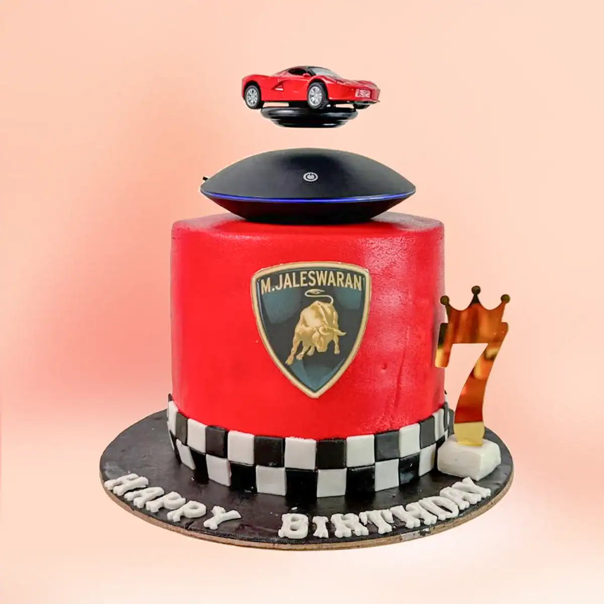 Lamborghini theme birthday cake in Chennai with red fondant, a black and white checkered base and a real magnetic levitating sports car display on top from Cake Square.
