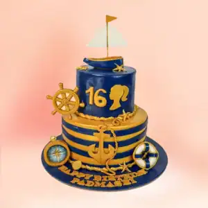 Two tier nautical theme Sweet 16 birthday cake in Chennai with navy and gold stripes, anchor, ship's wheel and sailboat toppers and a custom name banner from Cake Square.