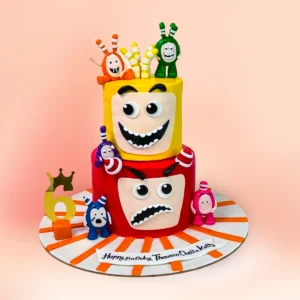 Two tier Oddbods cartoon theme first birthday cake in Chennai with yellow and red comic face tiers, colourful character figures and a custom name topper from Cake Square.