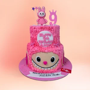 Two tier pink Labubu theme birthday cake in Chennai with textured pink buttercream, a Labubu figure topper and a custom name and age plaque from Cake Square.