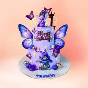 Two tier purple fairy theme first birthday cake for girls in Chennai with lilac buttercream, a fairy figure with butterfly wings and a toadstool house from Cake Square.