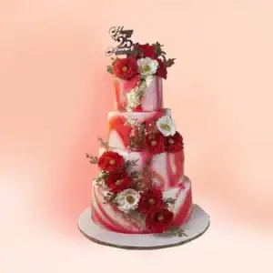 Four tier red and white marble anniversary cake in Chennai with gold leaf, red sugar carnations, white flowers and gold foliage, finished with a Happy 25th Anniversary topper from Cake Square.