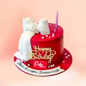 Red fondant luxury birthday cake in Chennai with a draped white fondant bow, pearl string detailing and a gold Happy Birthday topper from Cake Square.